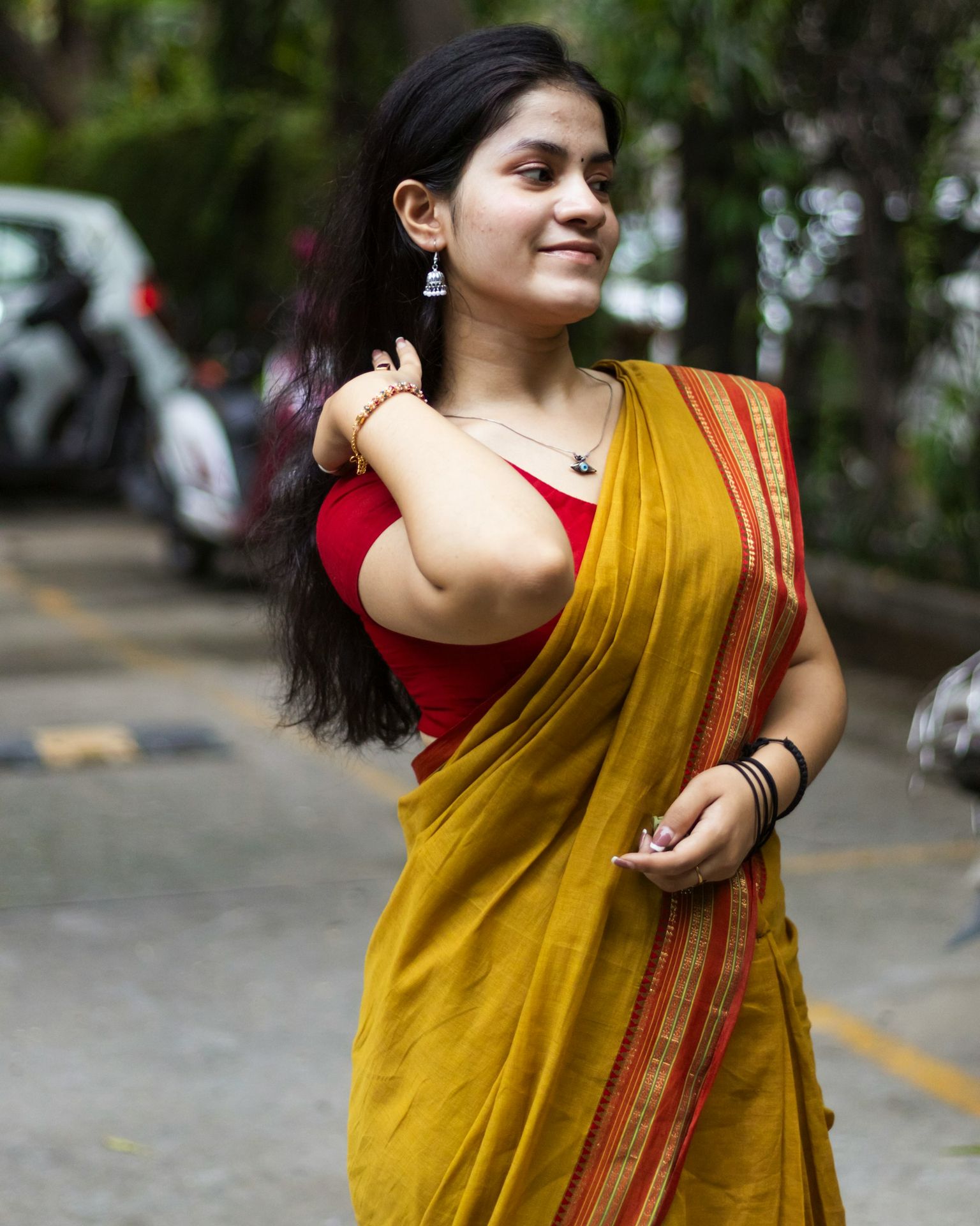 A woman in a yellow sari walking down the street